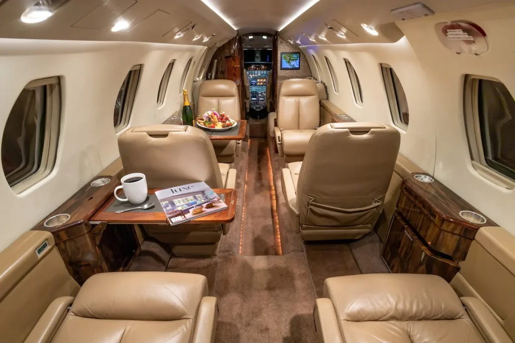 Interior of a Cessna private jet with nude leather seats and cream-colored walls.