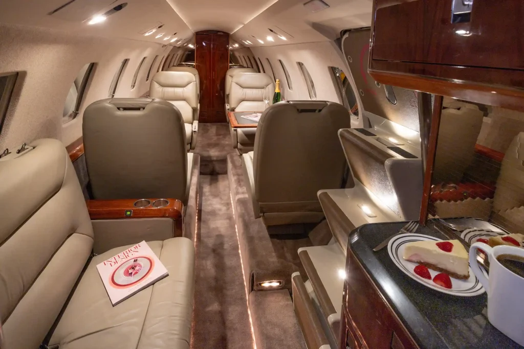 Interior of a Cessna private charter jet, with dark wood interiors.